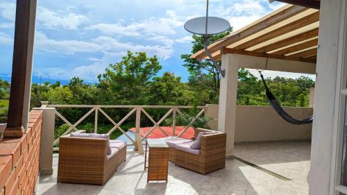 a porch with chairs and a hammock on a patio at Villa Paradise - Mar y Naturaleza in Punta de Piedra