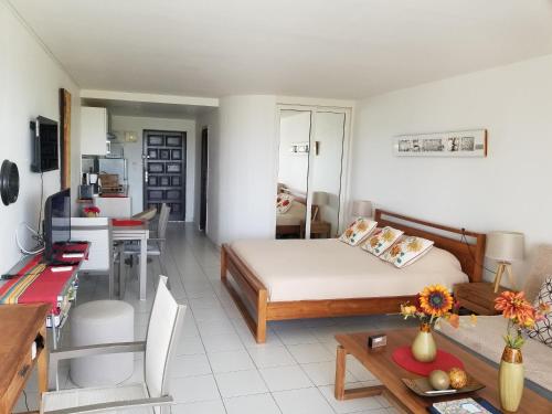 a living room with a bed and a table at Orient Bay Beach Studio in Orient Bay