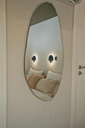 a mirror on a wall with a bed in a room at Houseboat by Noma in Saint-Étienne