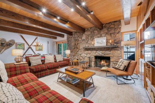 una sala de estar con sofás y una chimenea de piedra. en Lodge at Lionshead 380, en Vail