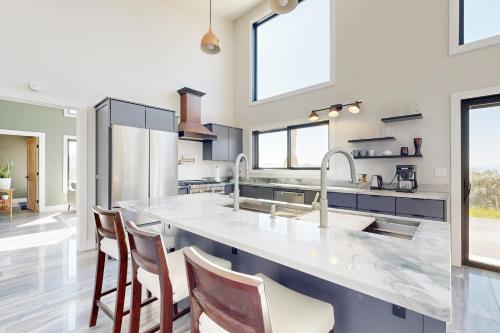 a kitchen with a large counter with stools at Timber Vista Retreat in Cedaredge