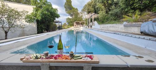 a table with wine glasses and food next to a swimming pool at villa Verdon 12 personnes piscine 25m in Salernes
