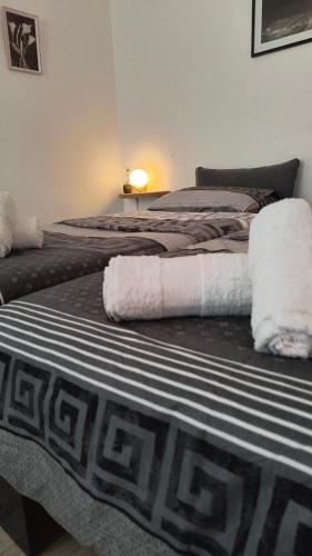 two beds with towels on them in a room at Odisea House in Ljubaništa