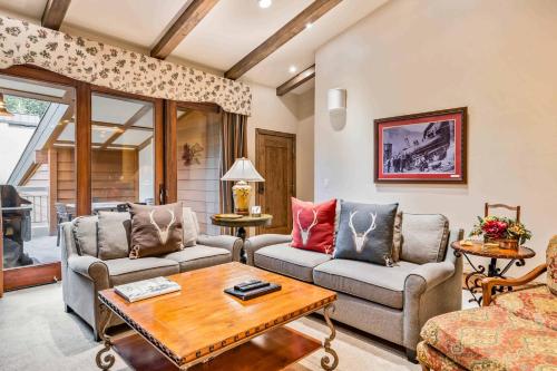a living room with two couches and a table at Lodge at Lionshead 404 in Vail