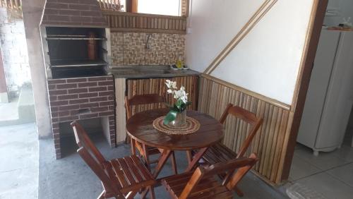 a wooden table with chairs and a vase of flowers at Vila dos Bangalôs in Barreirinhas