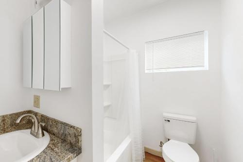 ホノルルにあるHonolulu Hideawayの洗面台とトイレを備えた白いバスルーム