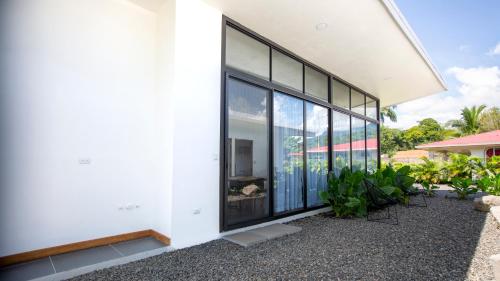 a white building with large windows and plants at Villa Tanager in Fortuna