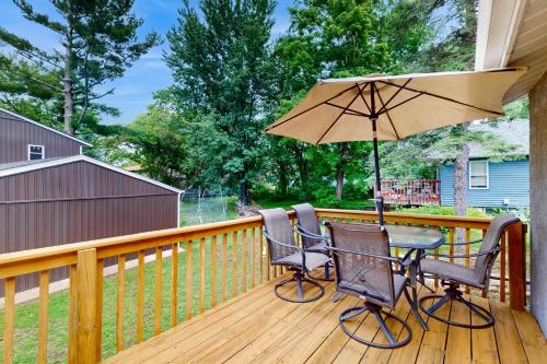 a patio table and chairs with an umbrella on a deck at Stucco House in North Hudson