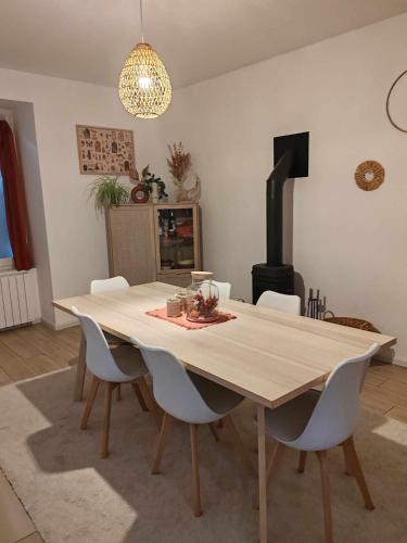 une table à manger avec des chaises blanches et une cheminée dans l'établissement Spacieuse maison proche mer, à Lanvollon