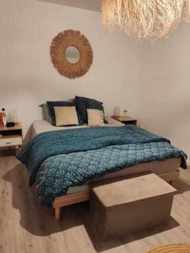 - une chambre avec un lit doté d'une couverture bleue et d'un miroir dans l'établissement Spacieuse maison proche mer, à Lanvollon