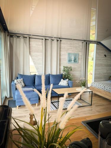 a living room with a blue couch and a table at Domy na wodzie Charzykowy in Charzykowy