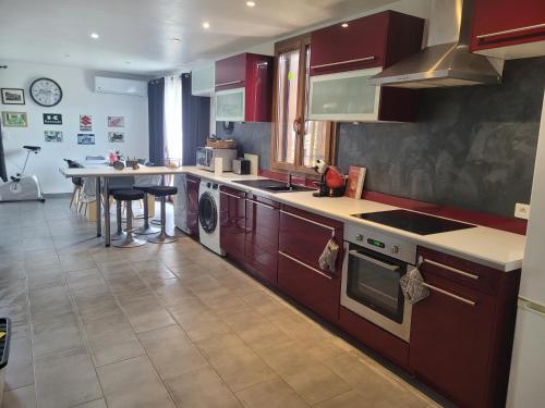 - une cuisine avec des placards rouges et une table dans l'établissement Le Chalet de Julia, à Vignale