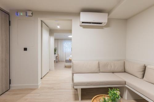 a living room with a couch and a kitchen at The Mediterranean Suites in Piraeus