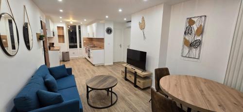 un salon avec un canapé bleu et une table dans l'établissement Appartement Saint Charles, à Marseille