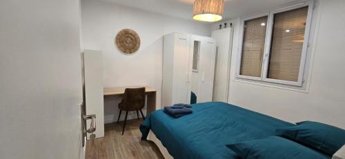 - une chambre avec un lit bleu et un bureau dans l'établissement Appartement Saint Charles, à Marseille