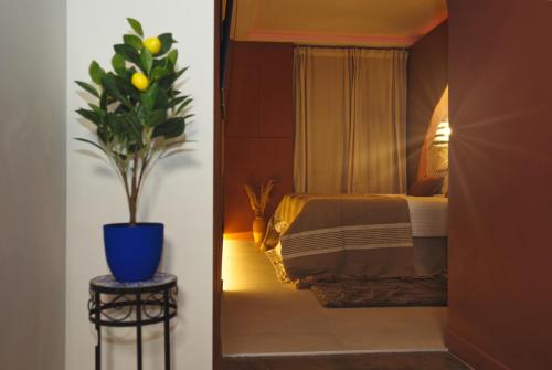 a bedroom with a bed and a potted plant at Suite Luxueuse Jacuzzi Hammam Marrakech by Noma in Saint-Étienne