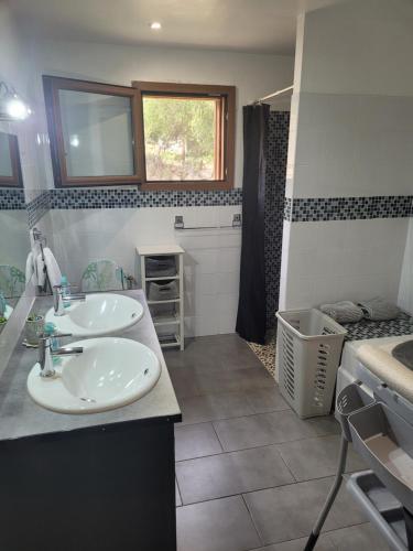 une salle de bain avec deux lavabos et une douche dans l'établissement Le Chalet de Julia, à Vignale