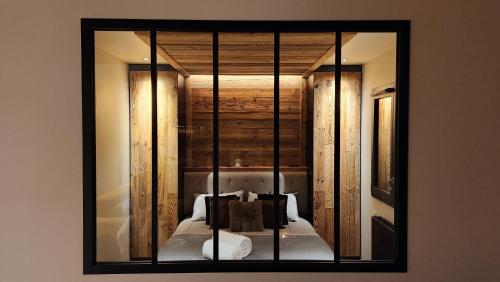 un miroir sur un mur avec un lit dans une chambre dans l'établissement Les Ô d'Ulysse, à Bourg-Saint-Maurice