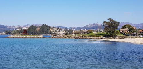 a large body of water next to a beach at Arenales Azules in Baiona