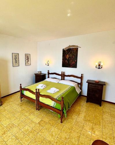 a bedroom with a bed with a green comforter at Villa Rosanna in Massa Lubrense