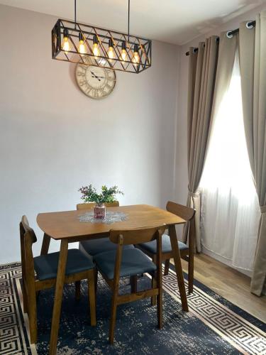 a dining room table with chairs and a clock on the wall at Homestay D'Humairah kg Chabau JASIN in Jasin