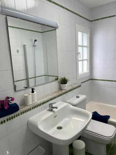a bathroom with a sink and a toilet and a mirror at Bungalow Retama in Tías