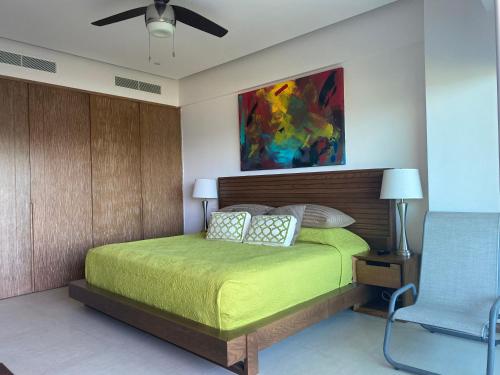 a bedroom with a bed and a fan and a chair at Peninsula Nuevo Vallarta in Mezcales