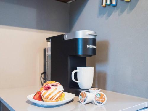 a coffee maker and a plate with a cake on a counter at "Sauna-fication" in West Seattle in Seattle