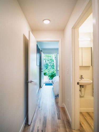 a hallway leading to a bedroom with a bed and a sink at "Sauna-fication" in West Seattle in Seattle