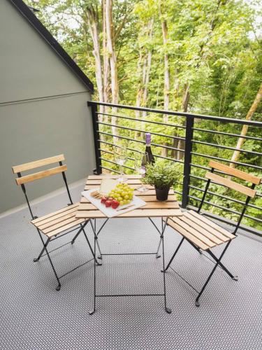 a table and two chairs on a balcony with a plate of fruit at "Sauna-fication" in West Seattle in Seattle