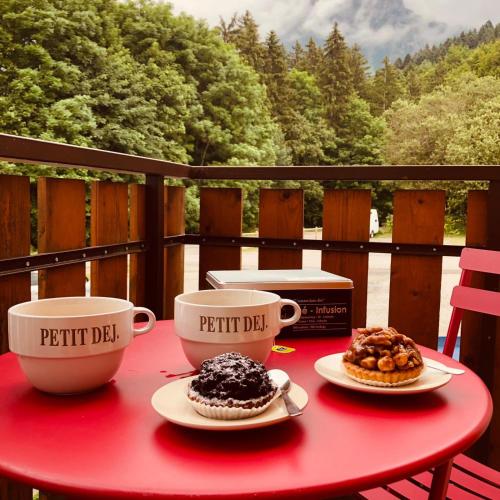 deux tasses de café et deux desserts sur une table dans l'établissement Studio Fondue chocolat, 100m des pistes Wifi fibre, parking privé, à Bernex