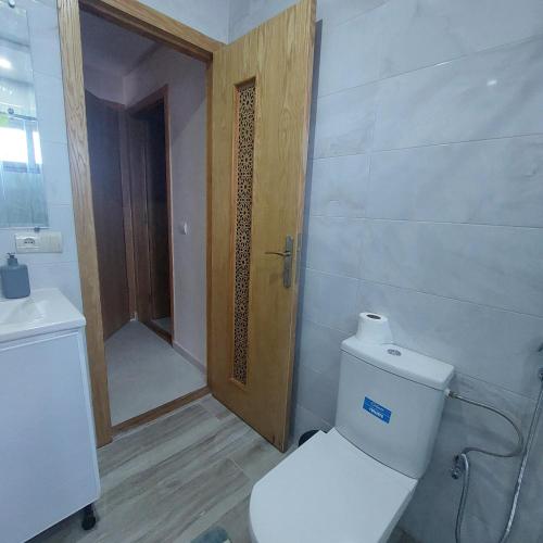 a bathroom with a toilet and a wooden door at Stylish Home, Mountain View, Netflix, Wifi in Chefchaouene