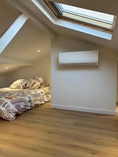 deux lits dans une chambre mansardée avec une lucarne dans l'établissement Appartement moderne, à Cagnes-sur-Mer