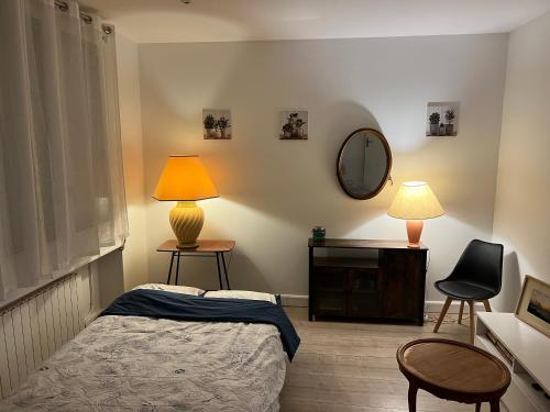 - une chambre avec un lit, un miroir et une lampe dans l'établissement A deux pas du Stade de France, à La Courneuve