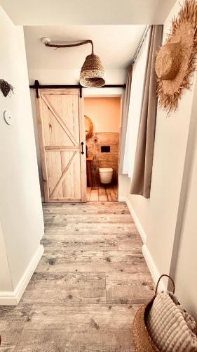 a hallway with a bathroom with a door and a toilet at Morze To Tu in Mielno