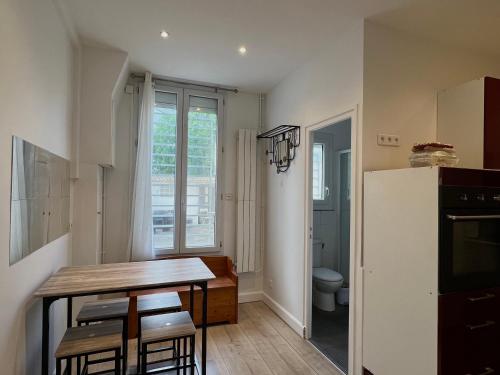 une petite cuisine avec une table et un réfrigérateur dans l'établissement A deux pas du Stade de France, à La Courneuve