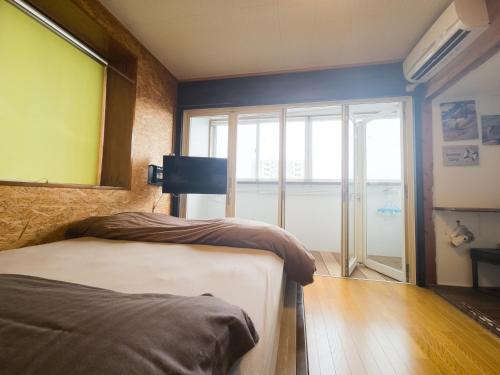 a bedroom with two beds and a large window at アワセベイストリートホテル in Okinawa City
