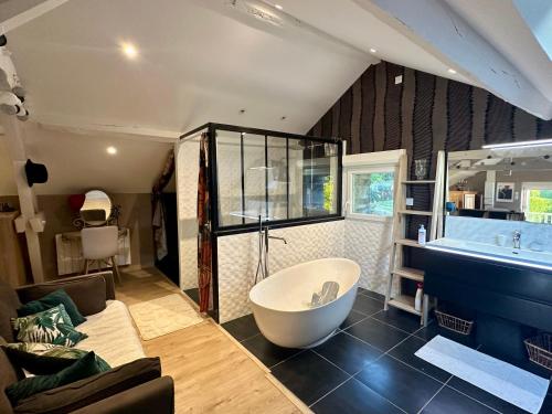 a large bathroom with a bath tub and a couch at Au Pied du Frêne in Bourganeuf