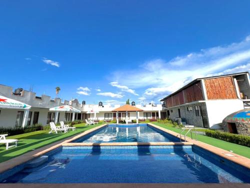 a swimming pool in a yard next to a building at Hotel El Jaguar in San Martín de las Pirámides