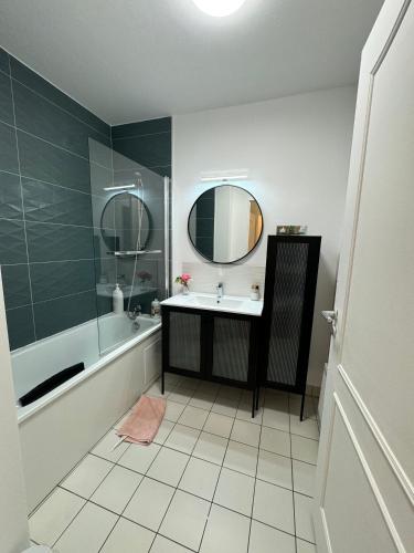 une salle de bain avec un lavabo, une baignoire et un miroir dans l'établissement Excellent Apartment for Familly, à Clichy