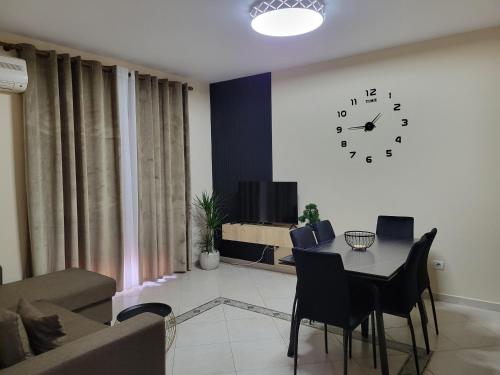 a living room with a table and a clock on the wall at Bella Vista Durazzo in Golem