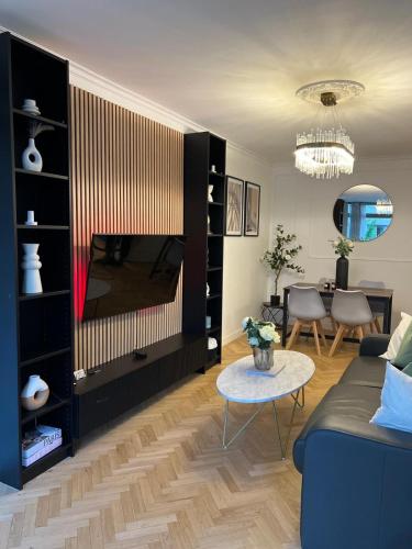 Una sala de estar con un sofá y un televisor. en Excellent Apartment for Familly, en Clichy