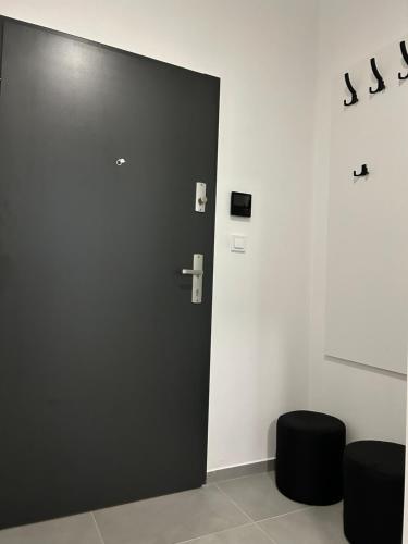 a black door in a room with black stools at AR SANTORINI white in Košice