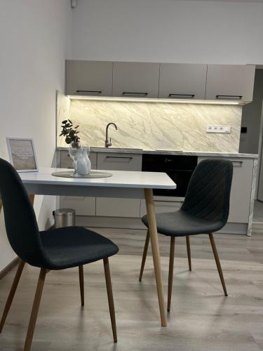 a kitchen with a table and two chairs at AR SANTORINI white in Košice