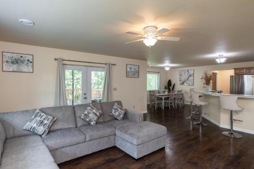 a living room with a gray couch and a kitchen at Birch Hill Homestay in Fairbanks