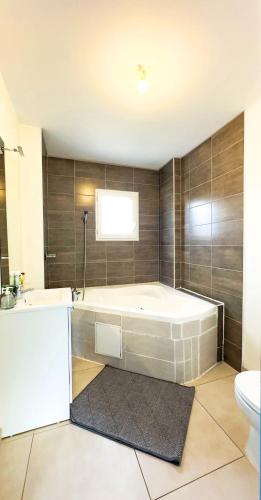 La grande salle de bains est pourvue d'une baignoire et de toilettes. dans l'établissement Business Room 10 minutes de Paris et Orly aéroport, à Antony