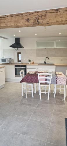 une cuisine avec une table et des chaises dans une pièce dans l'établissement Appartement cosy et confortable, à Brié-et-Angonnes