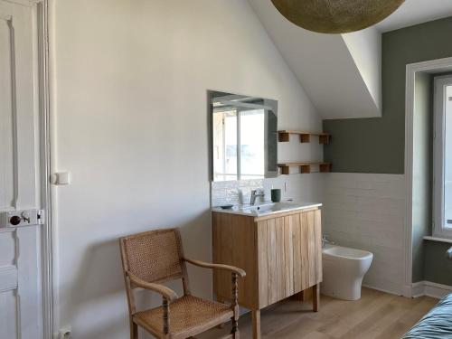 une salle de bain avec un lavabo et un miroir dans l'établissement Ker Mic Maison familiale rénovée 10 personnes 5 mn Plage et Centre Ville à pied, à Carantec