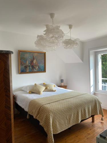 une chambre avec un lit et un tableau au mur dans l'établissement Ker Mic Maison familiale rénovée 10 personnes 5 mn Plage et Centre Ville à pied, à Carantec