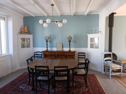 une salle à manger avec une table et des chaises dans l'établissement Ker Mic Maison familiale rénovée 10 personnes 5 mn Plage et Centre Ville à pied, à Carantec